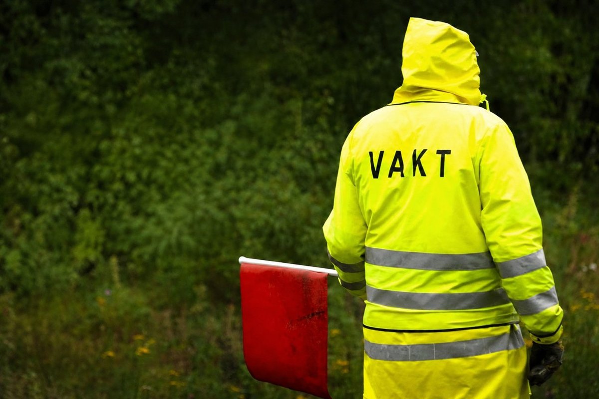 Flaggvakt som dirigerar trafiken vid ett vägarbete i Linköping